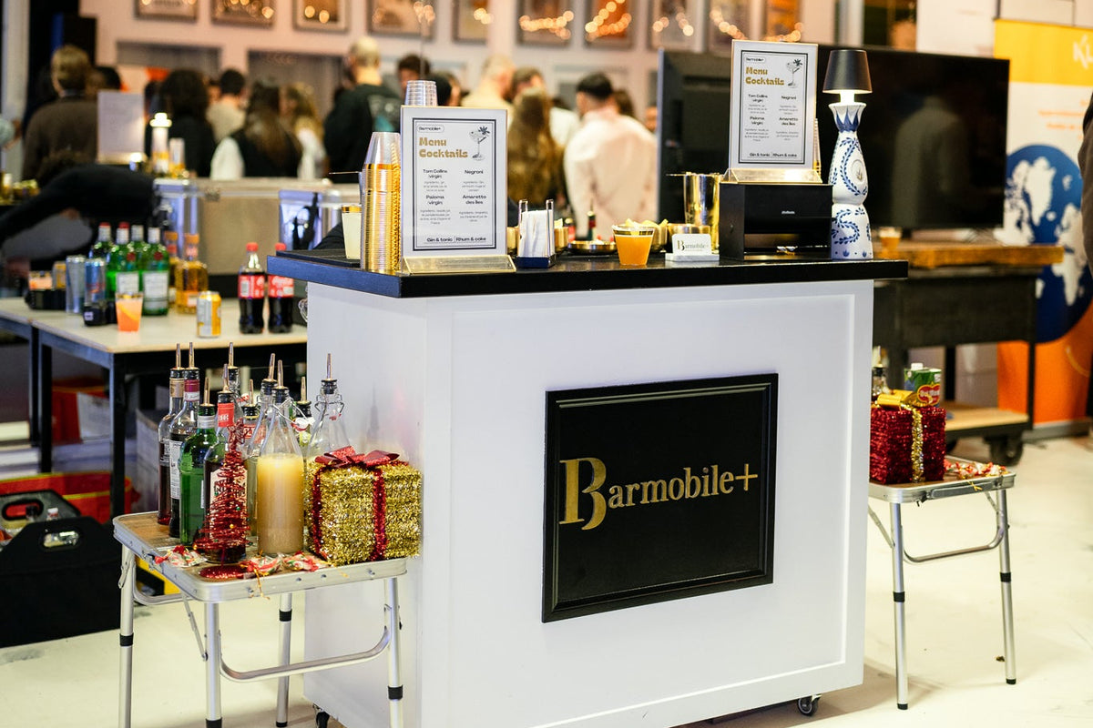 Bar mobile Barmobile+ décoré pour un party de Noël d'entreprise, avec boîtes-cadeaux et lumières